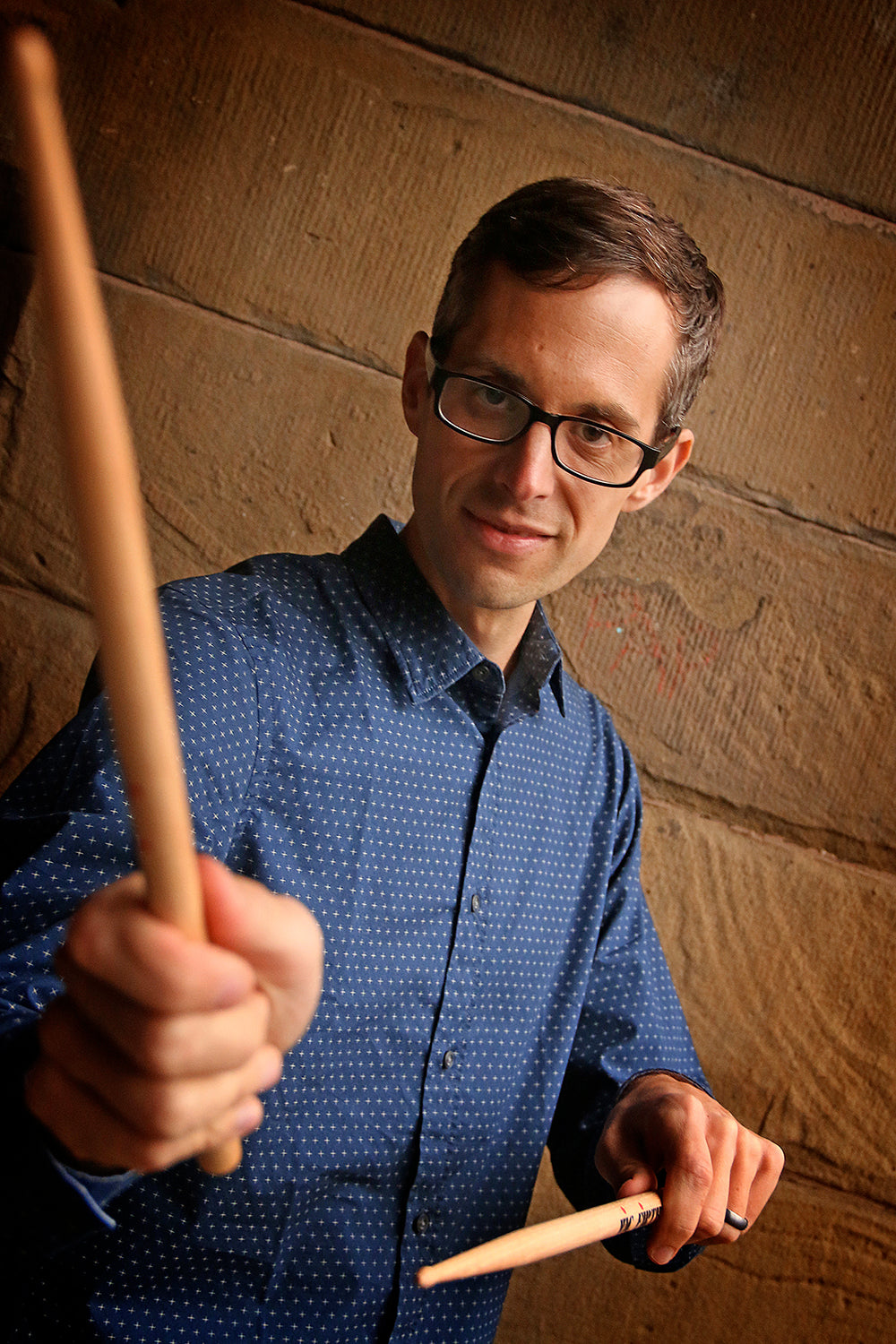 Matt Slocum holding Vic Firth drum sticks